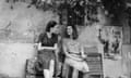 black and white shot of two women sat on a bench looking at each other smiling