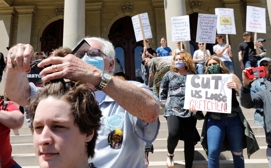 Barber Karl Manke gives free haircuts outside the Michigan state capitol in Lansing, Michigan, 20 May 2020, in protest at business closures