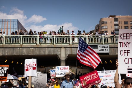 crowd of people hold up signs in protest