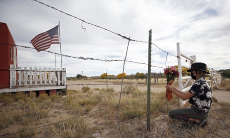 A woman places a bouquet at the entrance of the Bonanza Creek film ranch in Santa Fe, New Mexico.
