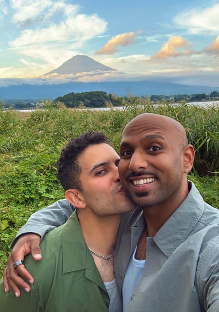 Daniel and his boyfriend taking a selfie; Daniel is kissing his boyfriend. Mount Fuji is visible in the background.