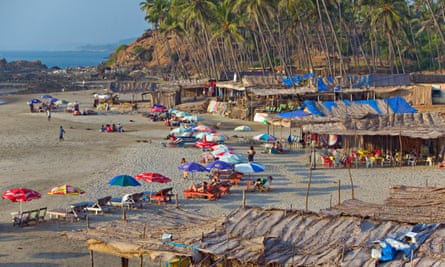 Daylight, and tourists enjoy relaxing on the sand at Vagator Beach, Goa.