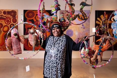 Artist Rhonda Sharpe with her work, as part of the installation of soft sculptures by Yarrenyty Arltere Artists in Larapinta Valley Town Camp, Mparntwe (Alice Springs).