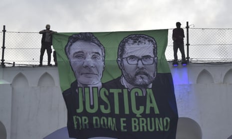 Protesters in Rio De Janeiro with a banner calling for justice for the murdered Guardian contributor Dom Phillips and Indigenous expert Bruno Pereira, who were killed in June 2022.