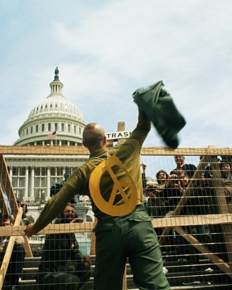 A GI throwing his combat jacket over a fence at a Vietnam war demonstration in Washington DC.
