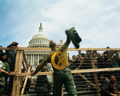 A GI throwing his combat jacket over a fence at a Vietnam War demonstration in Washington DC.