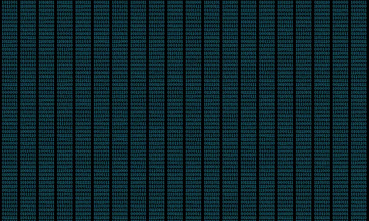 Binary code, ones and zeros in a 1970 dot matrix font on a computer screen.