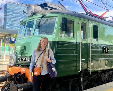 Caroline Eden posing in front of the front of a train