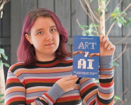 Maddie holds up a copy of her zine called ‘Art v AI’