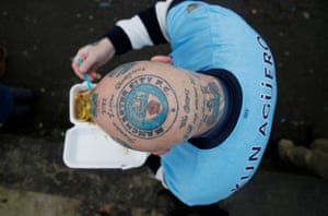A Manchester City fan proudly displays a head tattoo outside the Etihad Stadium before the match with Arsenal on Sunday.