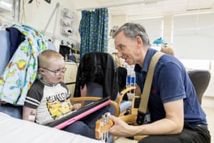 Ben Eccleston-Barnes, from Devon, is visited by volunteer music therapist Brian in Rose ward