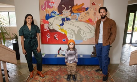 Clarissa et Tim Harris et leur enfant se tiennent devant le tableau Mlak dans leur maison