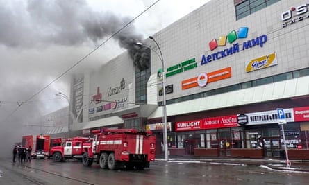 Emergency vehicles gather outside the burning shopping centre in Kemerovo.
