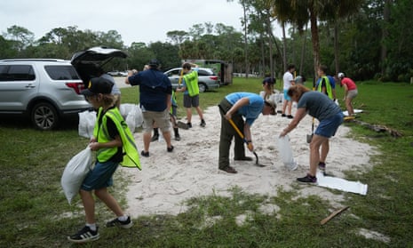 A Park Ranger directs traffic as Pinellas County residents arrive to fill sandbags at John Chestnut Park in Palm Harbor, Florida on October 6, 2024.