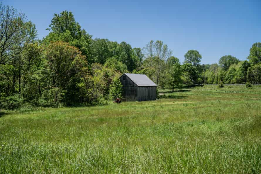 A farmhouse in the distance under a blue sky
