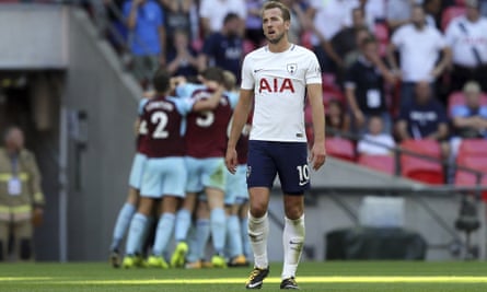 Tottenham Hotspur’s Harry Kane reacts as Burnley players celebrate scoring their late equaliser.