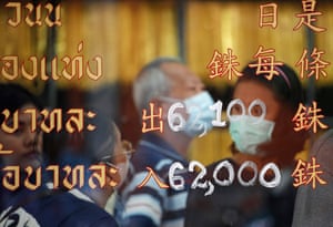 Customers’ reflections on a pane of glass displaying recently-updated gold valuations