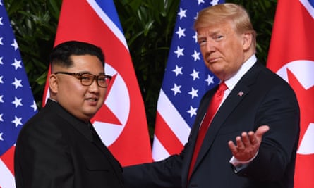 Kim Jong-un standing Donald Trump with flags in background.