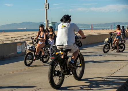 People ride legal e-bikes on the Strand in Hermosa Beach, California.