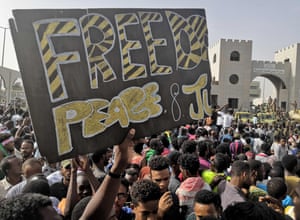 Sudanese anti-regime demonstrators hold up a banner calling for 'Freedom, Peace and Justice'