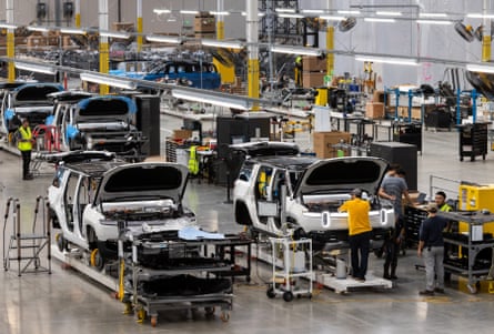 people stand in warehouse with new cars