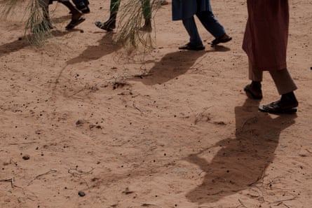 As ordered by their leader Boukhary, men walk in a diagonal line across the desert whooping and yelling as they practise a variety of fire-fighting formations
