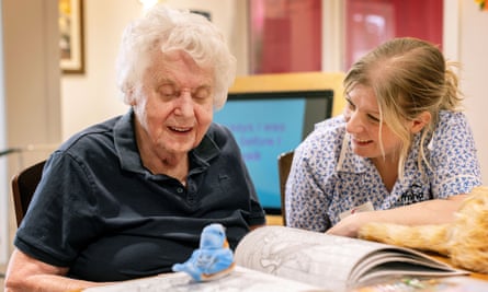 Shelia Gardener smiles at a robot bird with activity coordinator, Lydia Endersby