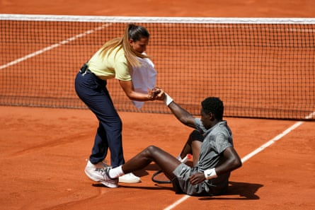 The Brazilian chair umpire Ana Carvalho helps Moïse Kouamé to stand up after he fell while playing Adolfo Daniel Vallejo