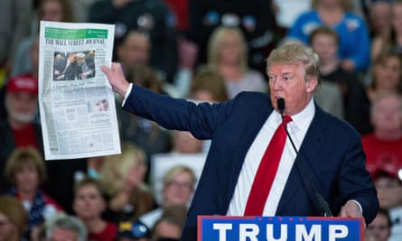 Donald Trump holds up a copy of the Wall Street Journal during a campaign rally on 24 November 2015 in Myrtle Beach, South Carolina.