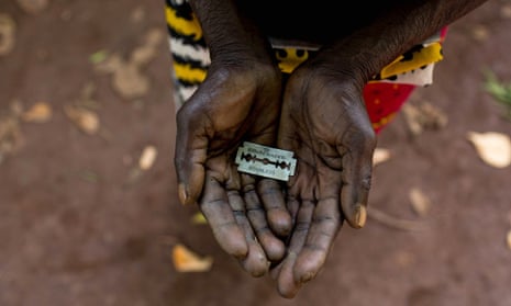 A cutter in Africa holds a razor blade she uses to carry out female genital mutilation.