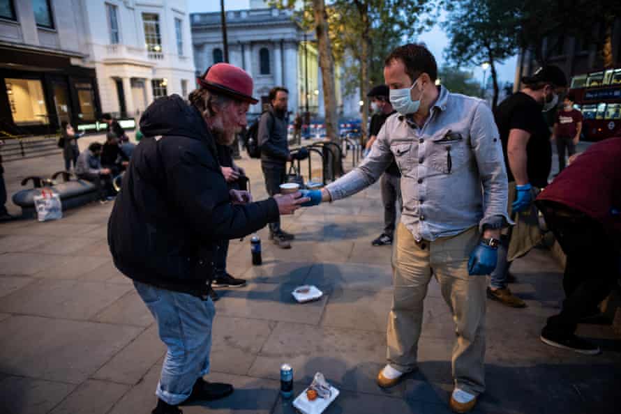 Volunteers with the charity Under One Sky give hot food and drink to homeless people in St Martins in the Fields, London.