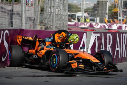 McLaren driver Lando Norris clambers out of his car after being wiped out by Franco Colapinto