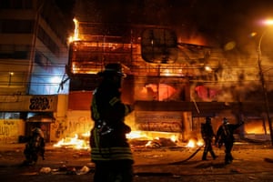 Firemen work to put out fires at a supermarket in Valparaíso