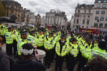 Dozens of police officers standing in formation in Trafalgar Square