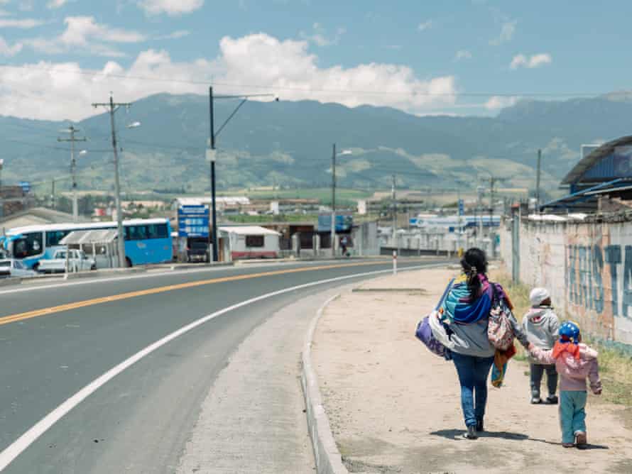 A Venezuelan mother walks with her two young children on the main road from the Ecuadorian border town of Tulcan towards Quito.