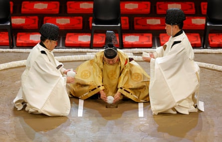 The gyoji (referees for the tournament) pour sake into the blessing hole