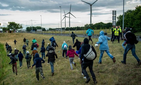Migrants run pass police in Coquelles near Calais
