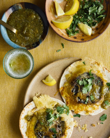 Santiago Lastra’s mushroom costras are big mushrooms with cheese on top and a dark green sauce on the side.