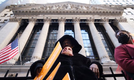An activist holds a mask in his mouth during an ‘eat the rich’ protest outside the New York stock exchange in January