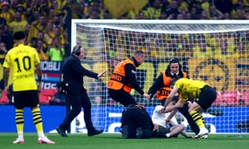 Stewards and players confront a pitch invader during the Champions League final between Borussia Dortmund and Real Madric.