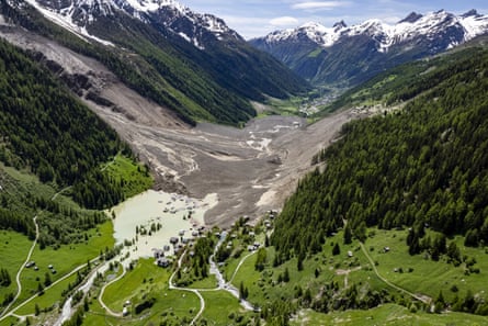 A town submerged by ice, rock and debris in a mountain valley.