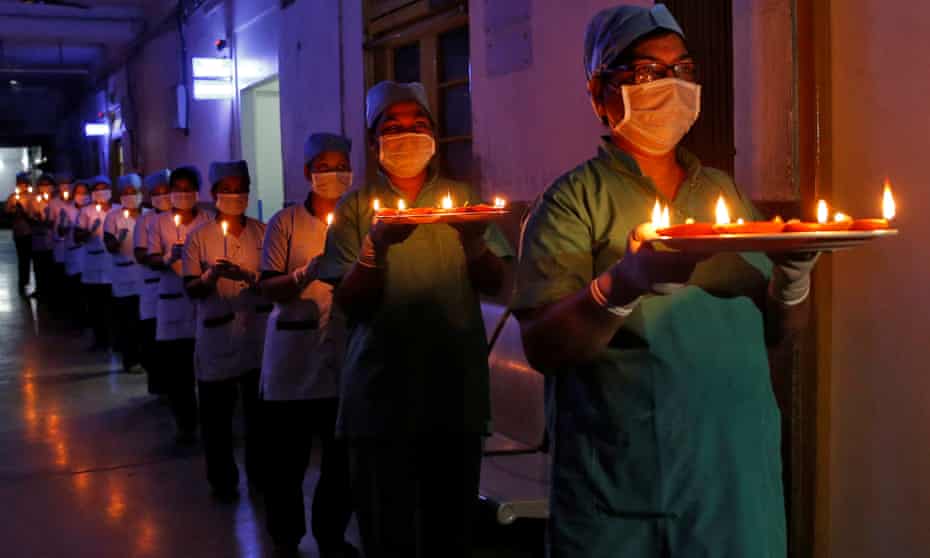 Healthcare workers at a Kolkata hospital carry candles and oil lamps to show solidarity with people affected by coronavirus.