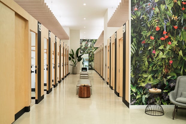 A row of fitting rooms inside Amazon Style where all the doors are made of light colored wood.