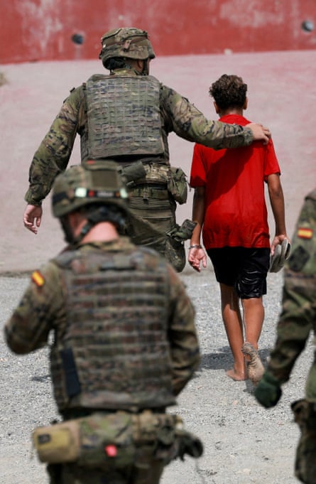 A young person being escorted by Spanish security forces