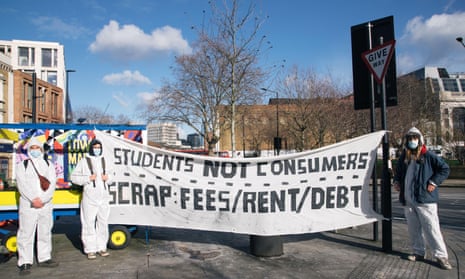 Students dressed in hazmat suits and masks protest in London against having to pay high rents and fees, holding banners stating they are students, not consumers.