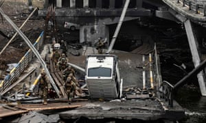 Ukrainian soldiers pass on a destroyed bridge at the entrance of Irpin, near Kyiv, on April 1, 2022, amid Russian invasion of Ukraine.