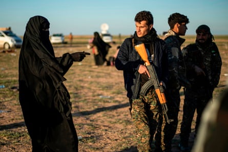 A member of the Kurdish-led Syrian Democratic Forces speaks with a woman leaving the Islamic Stategroup’s last holdout of Baghouz, 1 March 2019.