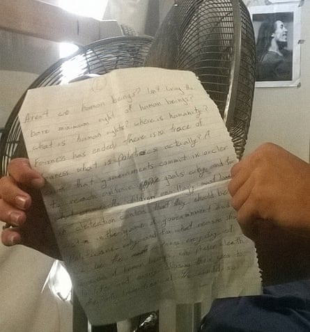 An asylum seeker holds a letter asking for the school to remain open