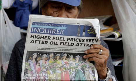 A sidewalk vendor reads a newspaper that headlines the recent attacks of Saudi oil refinery and raises global concern for a possible spike of oil prices Tuesday, Sept. 17, 2019, in Manila, Philippines. 