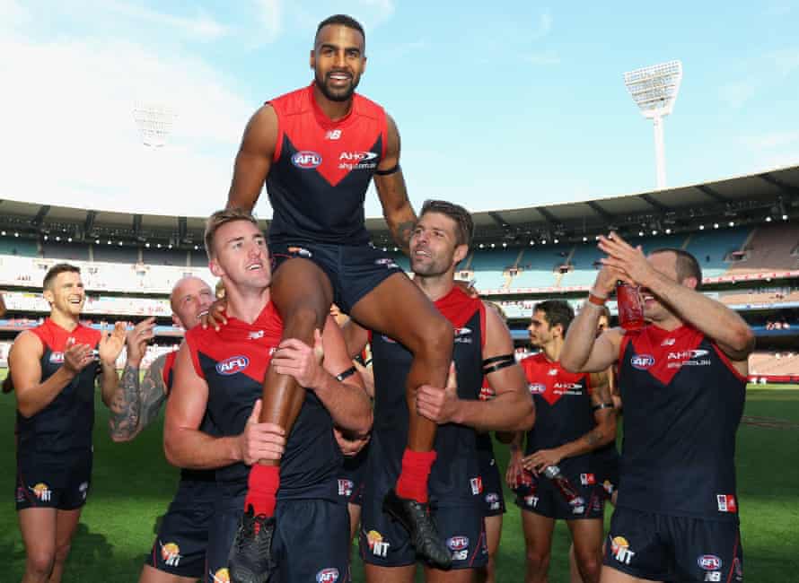Heritier Lumumba is chaired off by Melbourne players after playing his 200th AFL game.